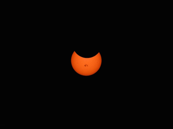 smaller version of the sun with the moon partially covering it up. some say it looks like a smiling jack-o-lantern with the sunspot