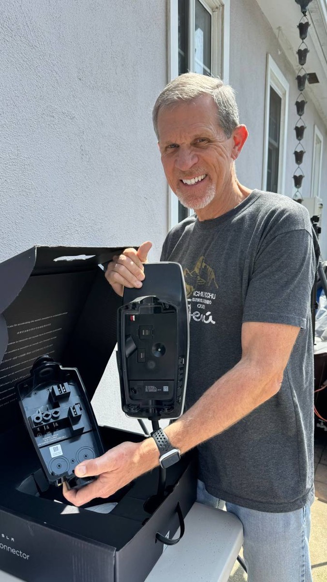 Steve holding replacement Tesla wall charger in two pieces.
