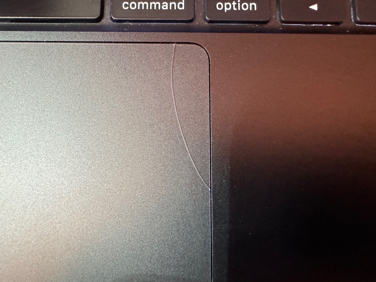 Cracked trackpad on MacBook Air closeup.