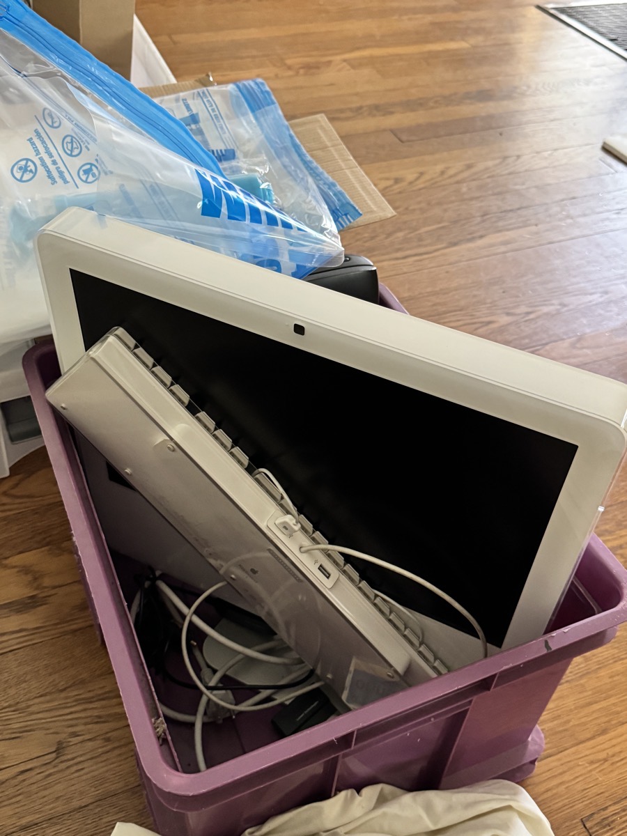 Attic flat imac forlornly crammed into a purple box with an old keyboard