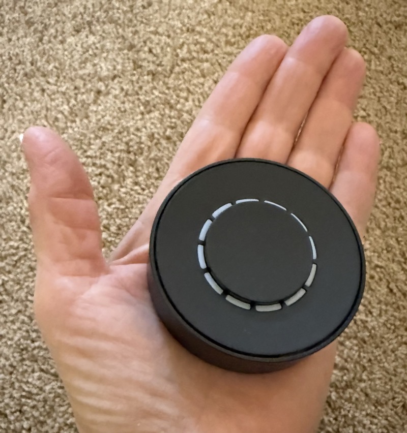 Flic Tiwst in the palm of my hand. It's a black puck with lights around it and a button in the middle