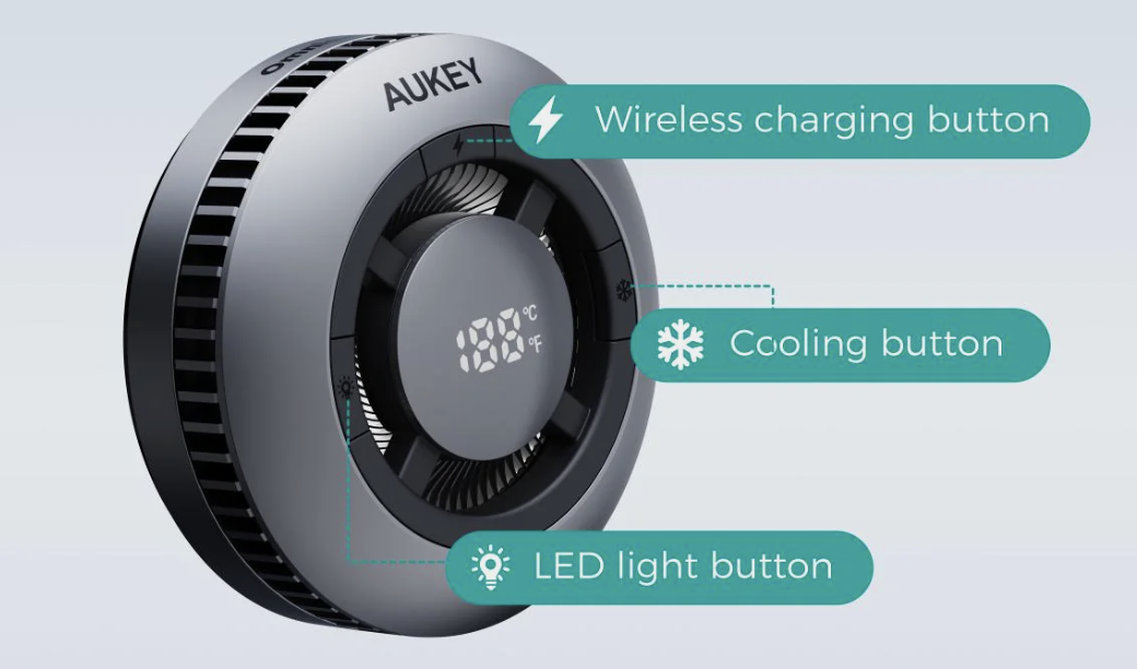 Front view of the Magfusion GameFrost Qi2 charger with the company name Aukey printed on the top of the charger face. It is circular, about 3 inches across and 1 inch thick. It has air vents on the periphery and on the front face of the charger. The face has a smaller circular disk that contains an LED display of temperature. The disk is suspended in the middle of the circular charger by four struts. In between the struts are small slits that can pass air and the hints of a small fan inside. Callouts appear next to three functions on the charger: 1) Wireless charging button, 2) Cooling button, and 3) LED light button.